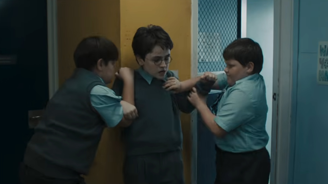 Dudley Dursley e sua gangue encurralando Harry Potter na escola - Amos Kitson na série HBO